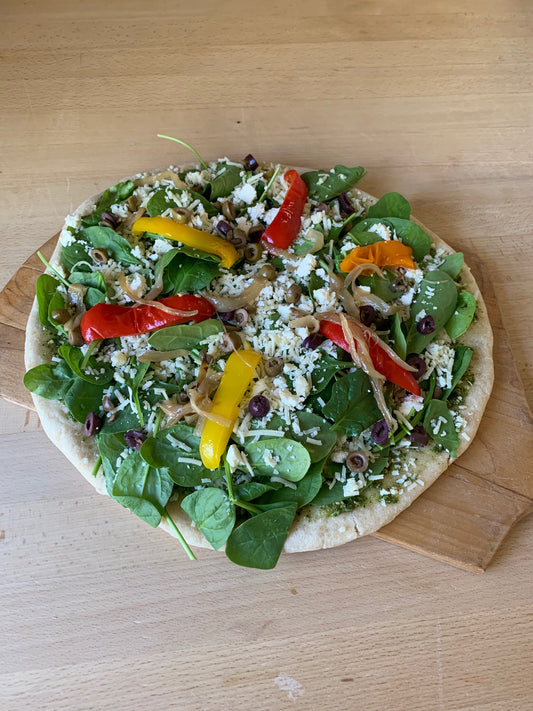 Mediterranean Pizza- Pesto, caramelized onions, spinach, roasted peppers, olives, asiago and feta cheese